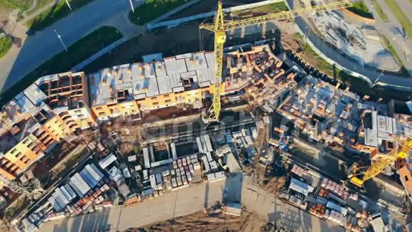 起重机靠近未完工建筑俯视图施工吊车在工地上新建砖房视频的预览图