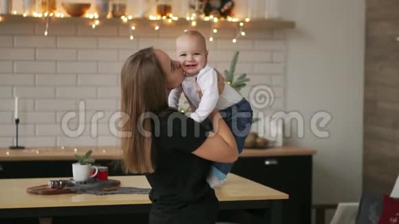 年轻的母亲抱着她新生的孩子慢动作家里的家人妈妈和孩子过圣诞节视频的预览图