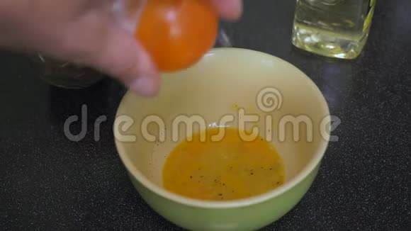 这个人把盐和胡椒粉加到新鲜的碎鸡蛋里他正在为食物准备调料视频的预览图