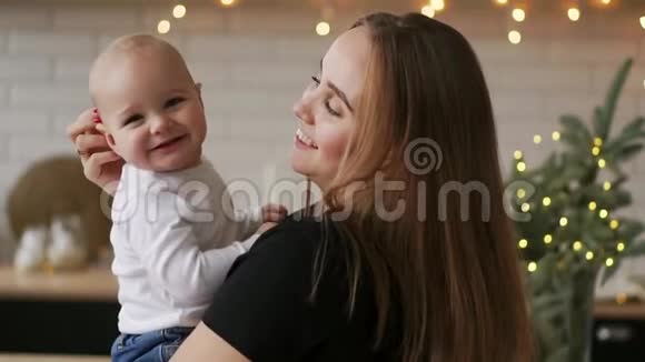 年轻的母亲抱着她新生的孩子慢动作家里的家人妈妈和孩子过圣诞节视频的预览图