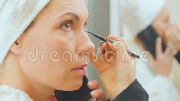 在美容店里一个女人在电话里讲话她在画眼睛视频的预览图