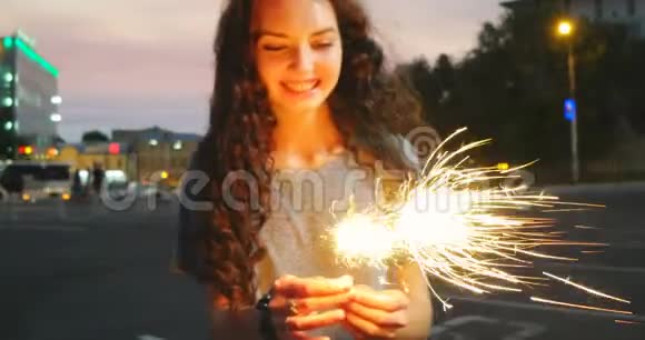 在城市日落的时候带着火花的欢乐女孩视频的预览图