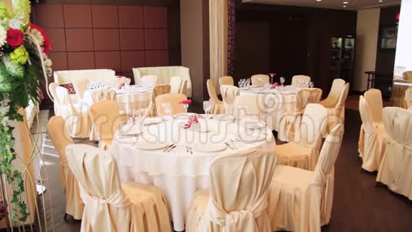 餐厅配有鲜花和空酒杯的餐桌场景带白色桌布的圆桌视频的预览图