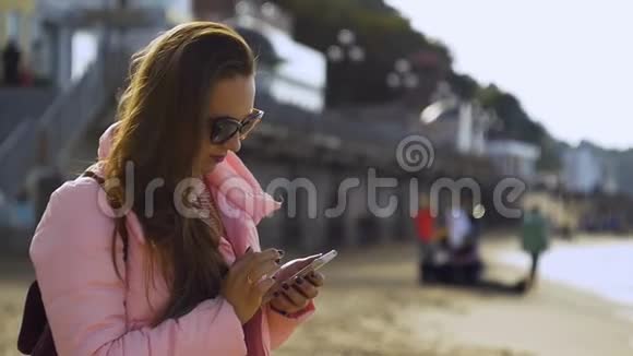 年轻女子在海上用智能手机发短信视频的预览图
