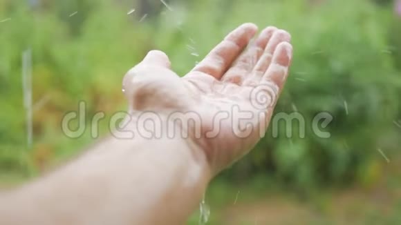 雨滴落在手中的雄性在雨中特写的手你看到水滴在他的手上跳动概念视频的预览图