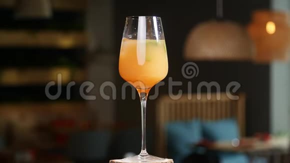 食饮概念冰块掉进飞溅的橙色鸡尾酒里视频的预览图