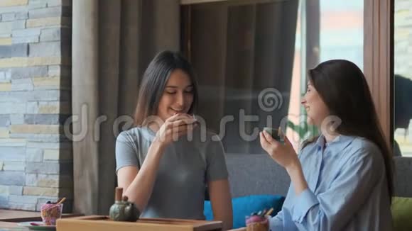 两个漂亮的女朋友在咖啡馆里聊天喝茶视频的预览图