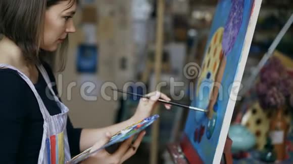 年轻的女画家在艺术学校的画布上画着静止的生活画面视频的预览图