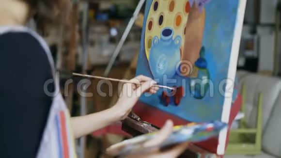 艺术类画画布上画家妇女用毛笔画静物画的特写镜头视频的预览图
