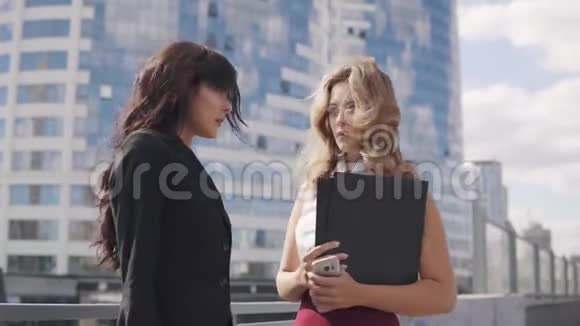 商业伙伴在讨论商务中心背景下穿着正式西装的两位商务女性视频的预览图