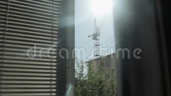 从窗户看建筑塔吊和房屋的轮廓视频的预览图