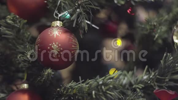 一只手把新年玩具挂在圣诞树上和新年装饰上摘要波克假日背景视频的预览图