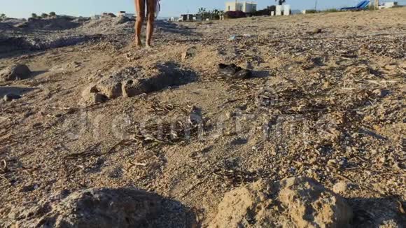 女人走在海边丢失的靴子附近视频的预览图