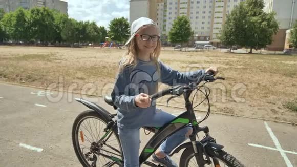 一个12岁的女孩在温暖的夏天骑自行车视频的预览图