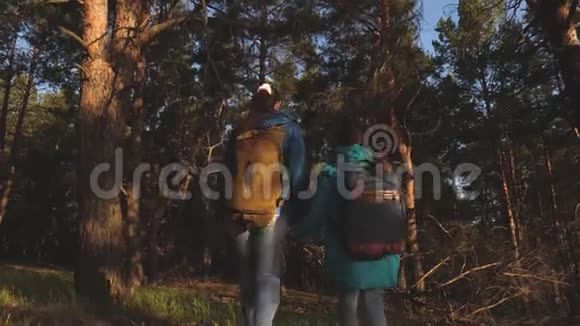 快乐的家庭旅行母女旅行者带着背包穿过树林一棵松树上的徒步旅行者视频的预览图