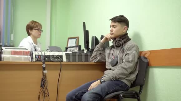 助听器一个青少年在医生接待病人从一位专家那里收听助听器视频的预览图