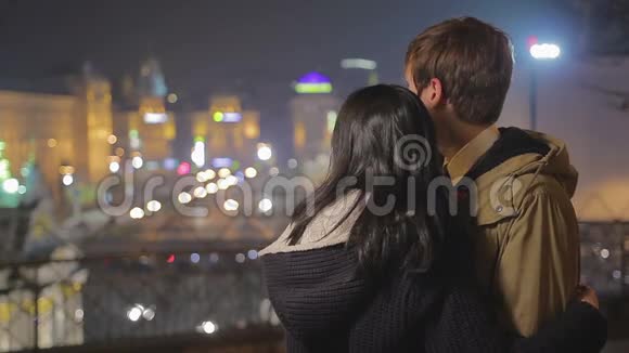 年轻浪漫的一对情侣拥抱看着美妙的夜景视频的预览图
