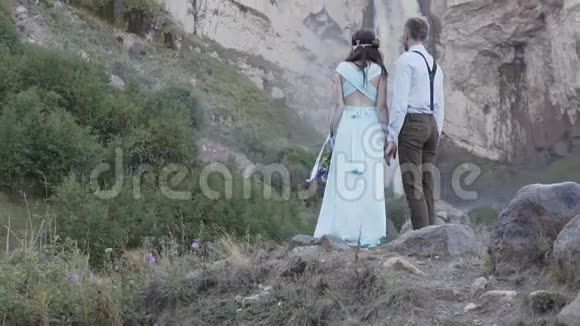 时尚的年轻夫妇在瀑布背景下摆姿势视频的预览图