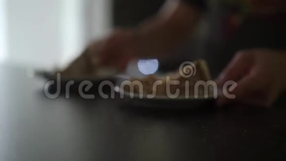 男人在餐桌上拿两块蛋糕和白巧克力奶油视频的预览图