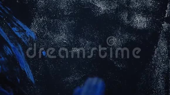 一个女人用蓝色油漆墙上的手印黑墙视频的预览图