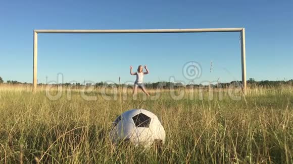 快乐的父亲和女儿在绿茵场上用足球大门打球快乐的家庭踢足球视频的预览图