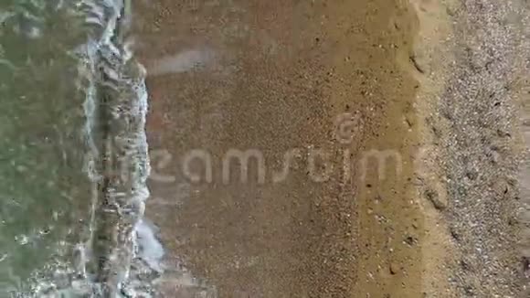 相机沿着海岸线移动波浪冲刷沙子视频的预览图