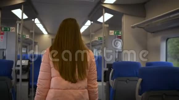 年轻漂亮的女人坐在火车车厢的乘客座位上掏出一个电话来写一条信息长发粉红色视频的预览图
