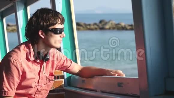 年轻的帅哥戴着太阳镜在海上享受航海旅行假期概念慢动作1920x1080视频的预览图
