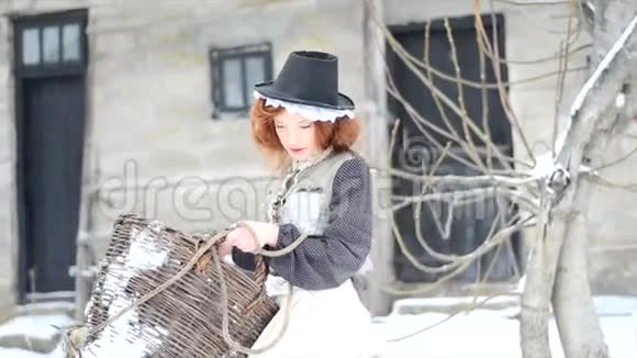 红发女孩带着一个大篮子在乡间别墅的院子里走来走去视频的预览图