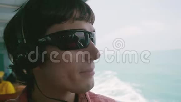 快乐时尚的年轻人戴着太阳镜一边漂浮一边在海边听音乐慢动作1920x1080视频的预览图