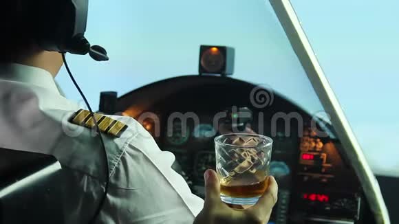 有趣的飞行员坐在飞机驾驶舱拒绝喝威士忌生活方式视频的预览图