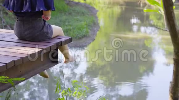 女人双腿悬在木船边视频的预览图