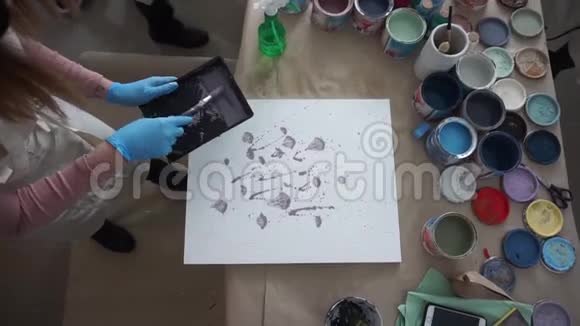 艺术家画了一幅抽象的画穿围裙的人油漆罐和刷子油漆飞溅视频的预览图