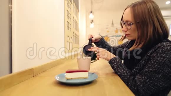 悲伤忧郁的女人喝热茶与奶酪蛋糕女孩把柠檬薄荷和肉桂倒入一个杯子里搅动着茶视频的预览图