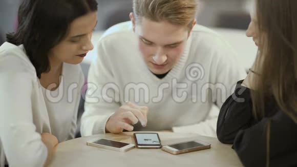 三个朋友看着智能手机的屏幕视频的预览图