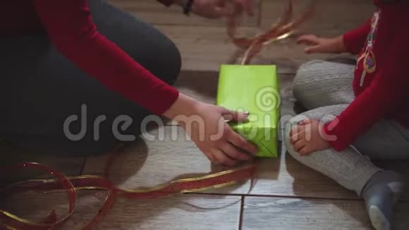 特写女人和女孩的手用盒子包装礼物以圣诞节和新年的颜色视频的预览图