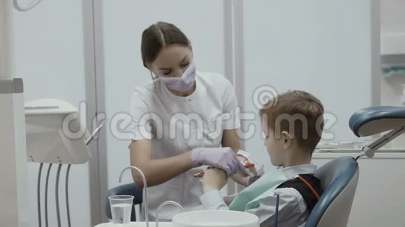 牙医教一个坐在口腔椅上的小男孩如何刷牙视频的预览图