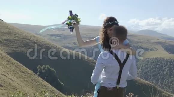 幸福的一对夫妇在群山的背景下双臂旋转视频的预览图
