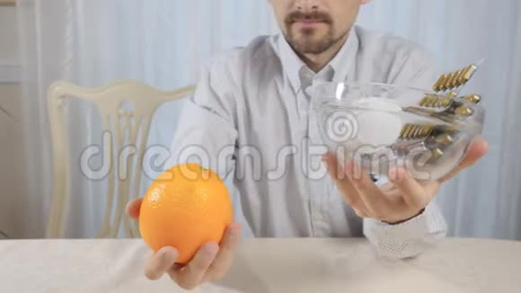 人与橘子花瓶与药丸保持平衡视频的预览图