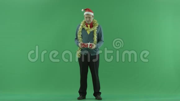 成熟的男人喜欢他的圣诞礼物绿色的关键背景视频的预览图