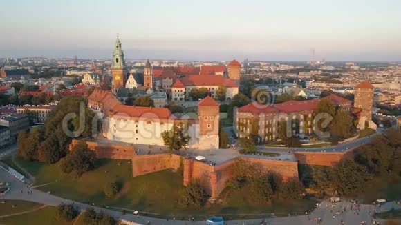 波兰克拉科夫皇家瓦维尔大教堂和城堡的鸟瞰图日落时有维斯图拉河公园庭院和游客视频的预览图