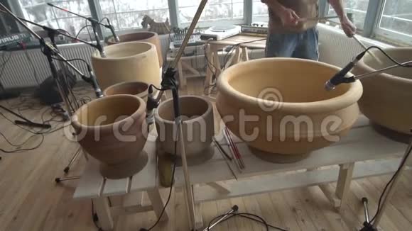 一个人在陶罐上演奏鼓槌的旋律视频的预览图