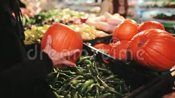 美丽的女孩正在选择一个南瓜与蔬菜站在超市秋季假日如万圣节视频的预览图