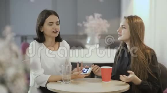 两位漂亮的女士在咖啡馆的餐桌上谈论着什么视频的预览图