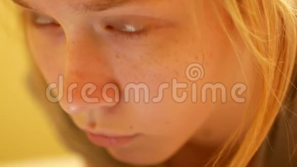 漂亮的金发白种人少女在家里躺在床上发短信视频的预览图