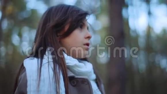 可爱的欧洲孩子长发和时尚的外观小女孩迷失在森林里站在森林的中央视频的预览图