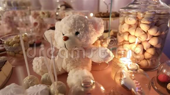 餐馆里的糖果吧孩子们聚会生日一只白色的泰迪熊脖子上有一只蝴蝶点燃蜡烛视频的预览图