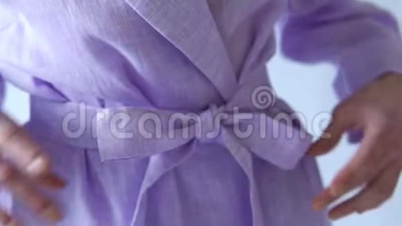 白色背景下女子紫色礼服蝴蝶结的特写细节视频的预览图