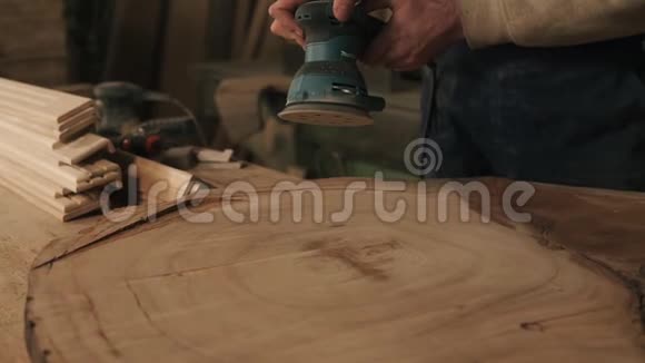 男人粗鲁的木匠用磨床处理木头用手检查光滑的表面视频的预览图