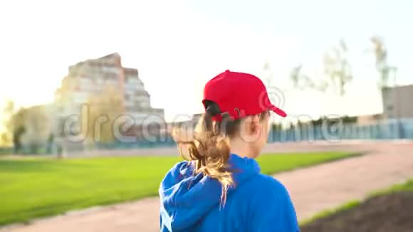 日落时分女人穿过体育场后景视频的预览图